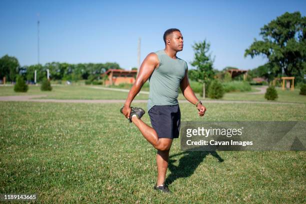 a proud strong athlete stretches in a park against blue sky - amusement park ohio stock-fotos und bilder