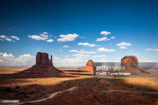shadows fall across the iconic stone formations at monument valley, az - valley icon stock pictures, royalty-free photos & images