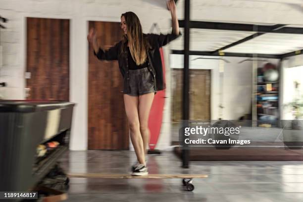 young woman riding skateboard - figure skater stockfoto's en -beelden