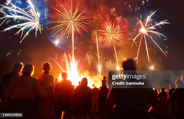 crowd in front of vibrant firework display - imagem super exposta imagens e fotografias de stock