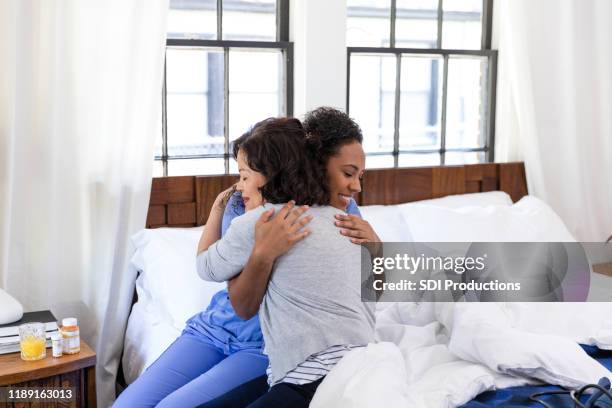 nurse gives patient big hug at end of visit - end of life care stock pictures, royalty-free photos & images