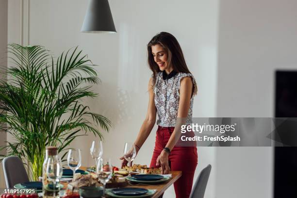 young woman setting up dinner table - party host stock pictures, royalty-free photos & images