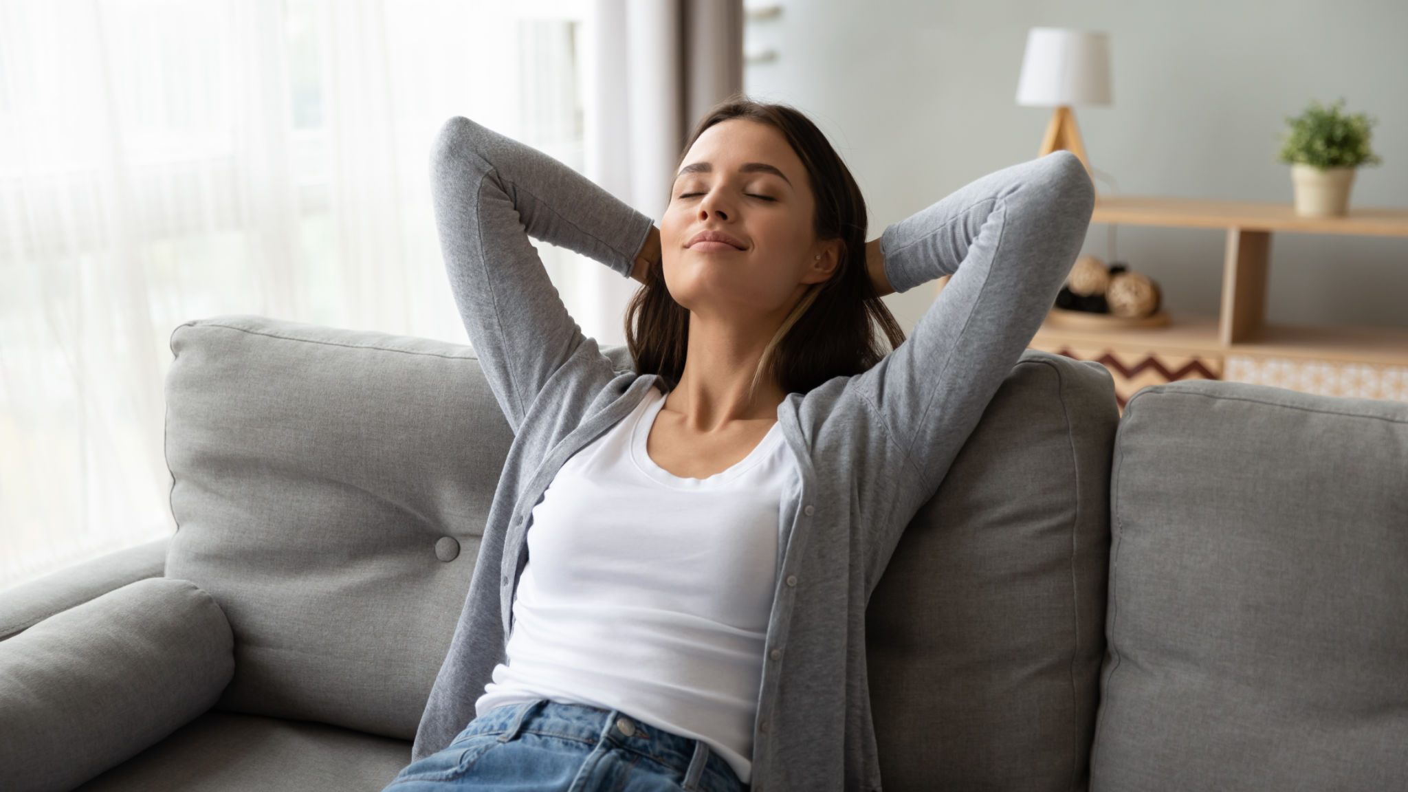 Relaxed serene young woman lounge on comfortable sofa at home Relaxed serene young woman lounge on comfortable sofa at home