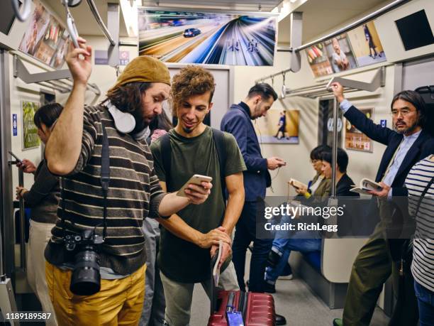 混雑した日本の地下鉄列車の観光客 - crowded train station smartphone ストックフォトと画像