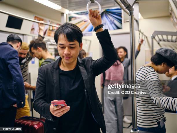 crowded japanese subway train - busy train stock pictures, royalty-free photos & images