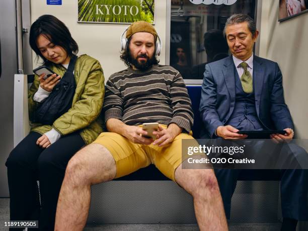 un homme prenant l'espace sur un train japonais de métro de foule - irrespect photos et images de collection