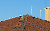 Tile roof with chimney and lightning protection system installed. Lightning rods. Close-up shot. Lightning conductor.