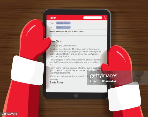 santa writing a email on a tablet device at a desk - computer cookies stock illustrations