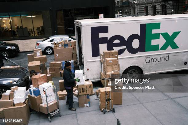 FedEx employee sorts boxes on the sidewalk on November 21, 2019 in New York City. As the internet increasingly becomes peoples preferred method for...