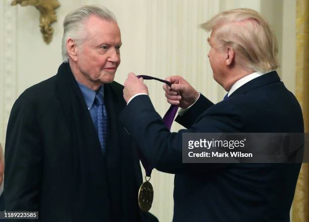 President Donald Trump presents actor Jon Voight with the National Medal of Arts during a ceremony in the East Room of the Whit House on November 21,...