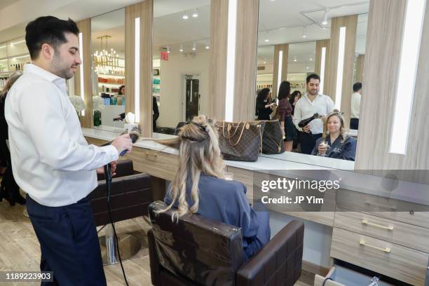 Roman Kusayev styles a client's hair at the Roman K Salon Madison Avenue Opening on November 21, 2019 in New York City.