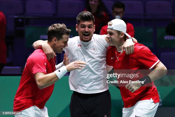 Vasek Pospisil and Denis Shapovalov of Canada celebrate with Canada team captain Frank Dancevic after winning the match in the quarter final doubles...