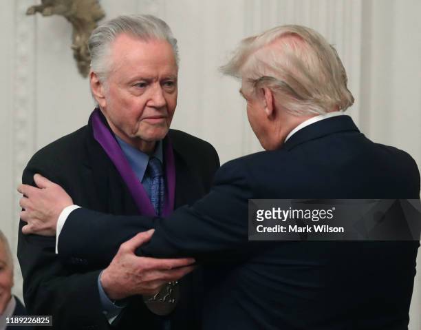 President Donald Trump presents actor Jon Voight with the National Medal of Arts during a ceremony in the East Room of the Whit House on November 21,...