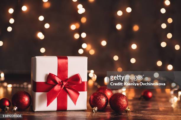 red christmas gift box and baubles on background of defocused golden lights. - funny christmas gift stockfoto's en -beelden