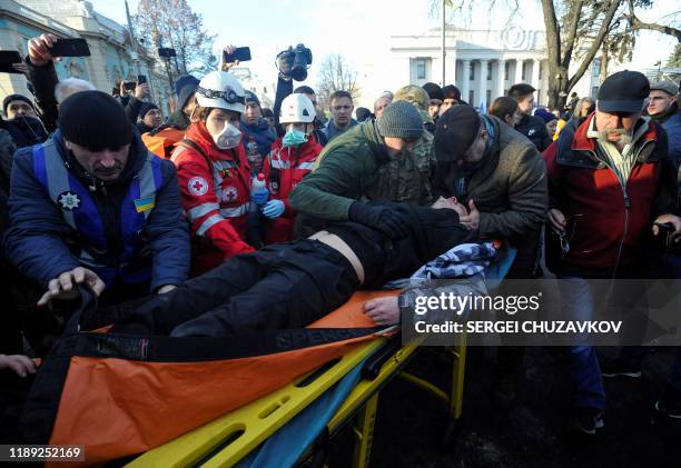 An injured activist is evacuated and transported on a stretcher following clashes during a protest against land sale reform in front of the Ukrainian...