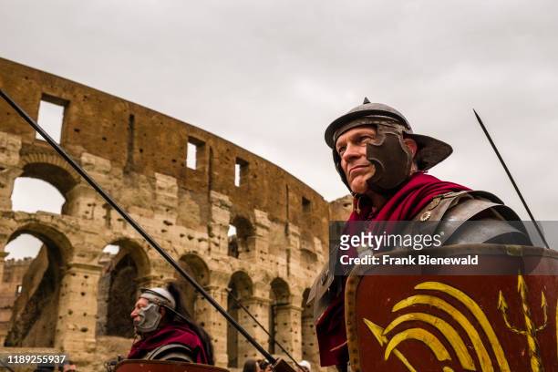 Historically dressed people taking part of the annual festival Natale di Roma, Rome's foundation anniversary, walking past the Colosseum.