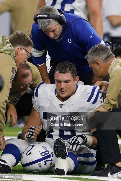Center Ryan Kelly of the Indianapolis Colts sits on the field and is attended to by medical staff a during the game against the Houston Texans at NRG...