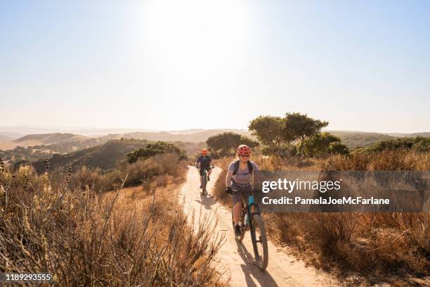 woman and man exploring single track trail on mountain bikes - trilho para bicicleta desporto ao ar livre imagens e fotografias de stock