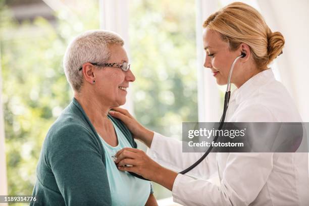 arzt hört den herzschlag des patienten - herzerkrankung stock-fotos und bilder