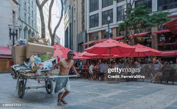 mann zieht einen wagen in der innenstadt von sao paulo - ungerechtigkeit stock-fotos und bilder