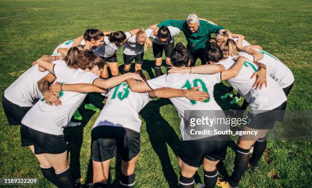 women soccer team and coach hugging - soccer team stock pictures, royalty-free photos & images