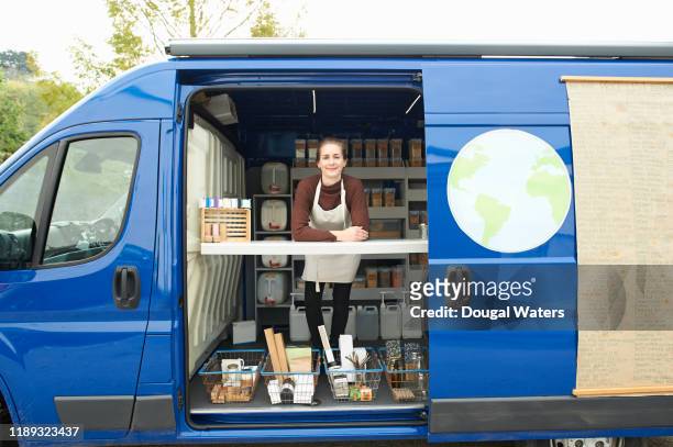 Small business woman working in zero waste wholefoods and local produce van.
