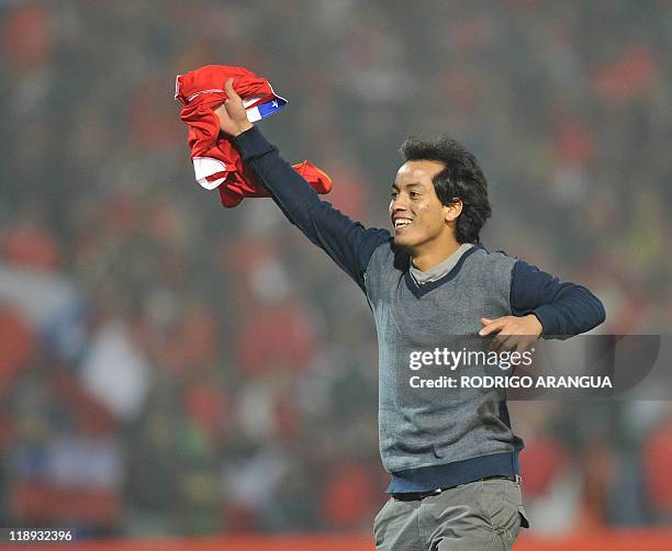 Chilean supporter celebrates waving his national flag during a 2011 Copa America Group C first round football match held at the Malvinas Argentinas...