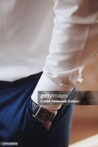 man's hand in the pocket of stylish trousers close-up. a successful young man who is a businessman, entrepreneur, expensive watches, fashionable in a simple white shirt. blurred background. - mens fashion wallpaper foto e immagini stock