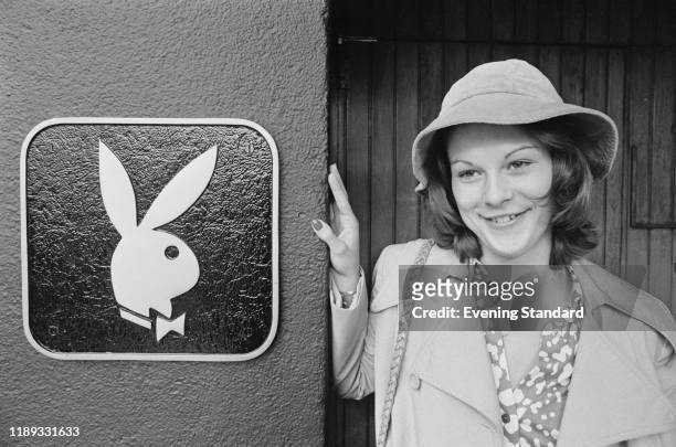 American businesswoman and activist Christie Hefner standing next to a Playboy sign, UK, 26th October 1976.