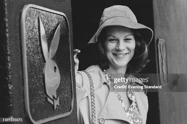 American businesswoman and activist Christie Hefner standing next to a Playboy sign, UK, 26th October 1976.