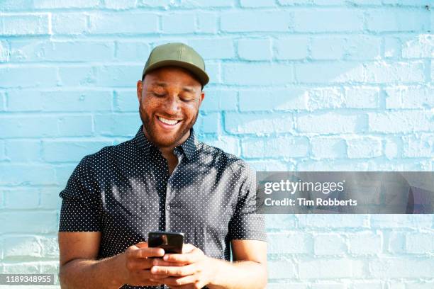 man smiling with smart phone - generation x stock-fotos und bilder