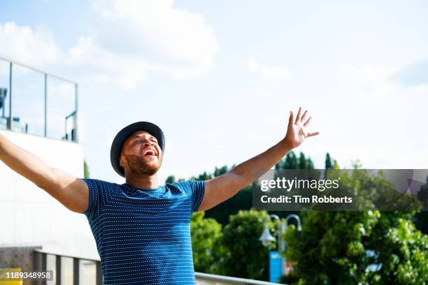 man celebrating with arms in air - best song stock pictures, royalty-free photos & images