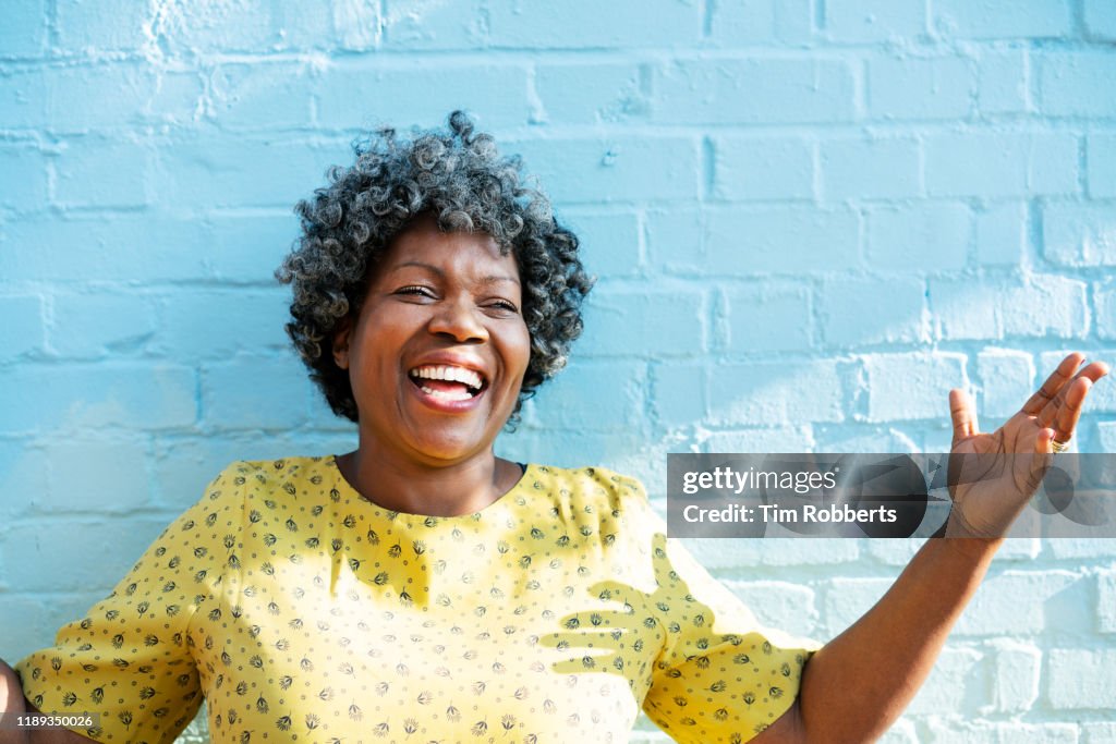 Happy woman laughing with arms up