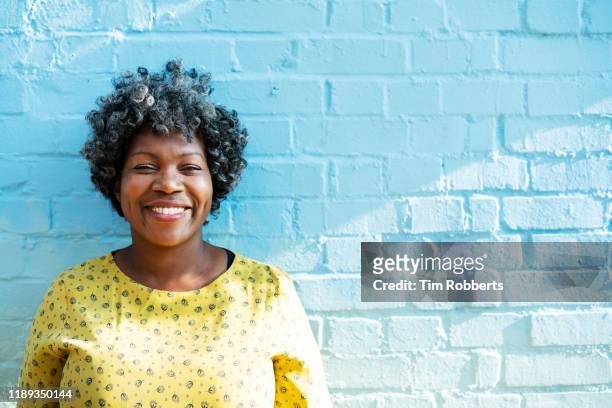 woman smiling at camera - afro frisur stock-fotos und bilder