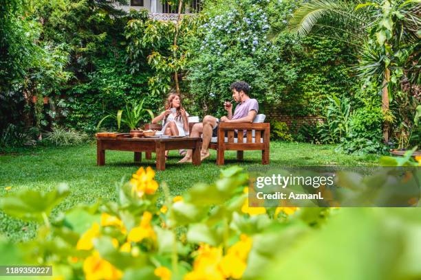 morning mate and coffee in lush backyard - lush backyard stock pictures, royalty-free photos & images