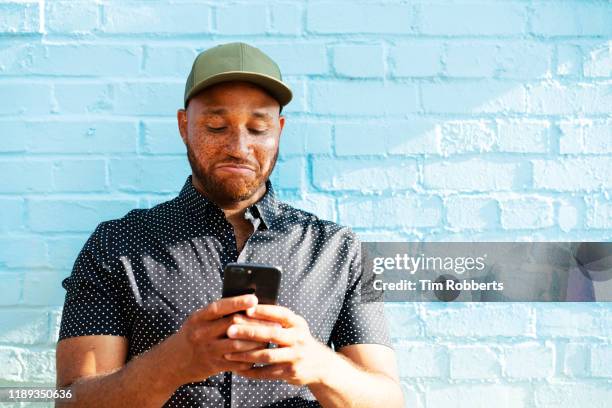 man reacting to smart phone - hombre asombrado fotografías e imágenes de stock