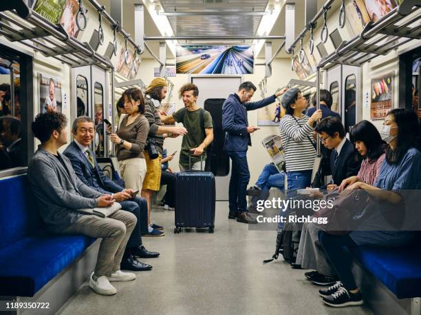 überfüllter japanischer u-bahn-zug - metro stock-fotos und bilder