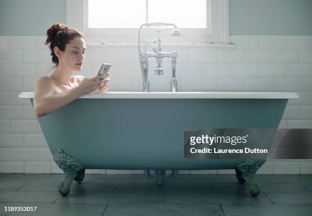 telefon bad frau - bathtub stock-fotos und bilder