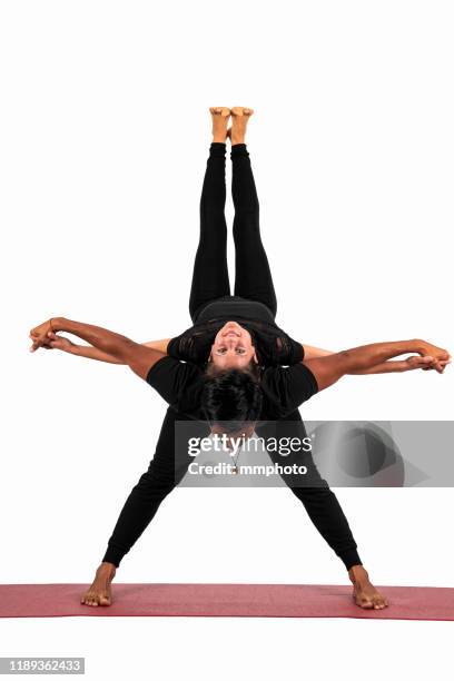 young adult couple practicing acrobatic yoga - trainer cutout stockfoto's en -beelden