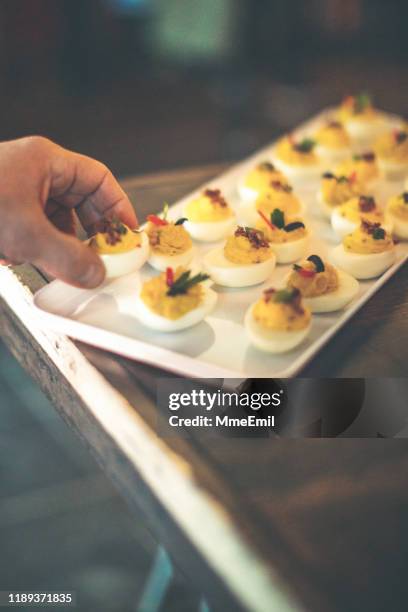 picking deviled egg - catering buffet stock-fotos und bilder