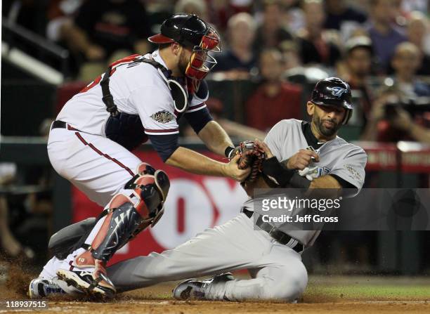American League All-Star Jose Bautista of the Toronto Blue Jays is tagged out by National League All-Star Brian McCann of the Atlanta Braves on a...
