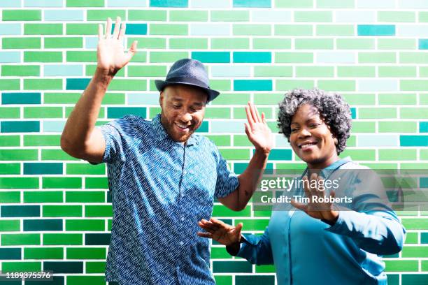 man and woman dancing next to wall - fat woman dancing stockfoto's en -beelden