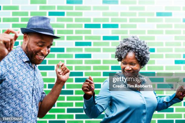 man and woman dancing next to wall - fat woman dancing stockfoto's en -beelden