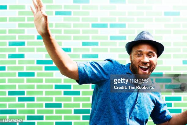 man with arm in air, dancing - colour background cool portrait photography joy stock pictures, royalty-free photos & images
