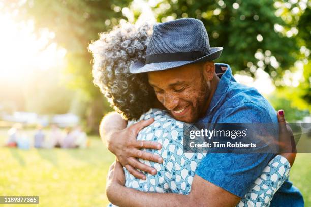 man and woman hugging in park - park family sunset stock pictures, royalty-free photos & images