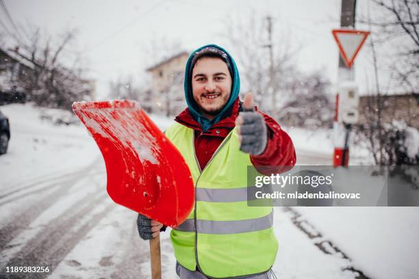 man with snow shovel - snow shovel man stock pictures, royalty-free photos & images