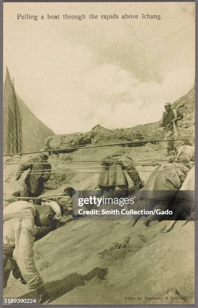 Monochrome postcard of a group of Chinese boat trackers pulling a boat upstream on the Yangtze River near Yichang, China, by photographer Denniston...