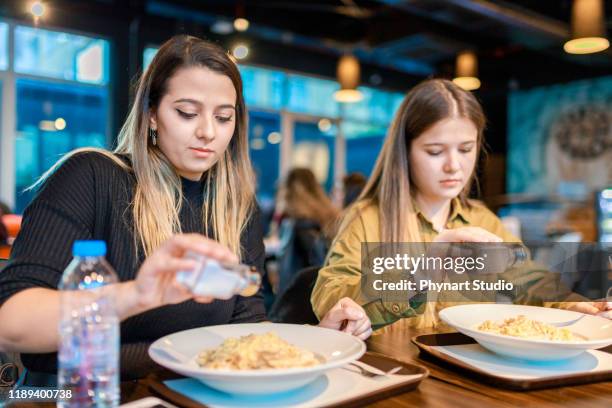 食べ始める前に塩とコショウを投げる人々 - 胡椒入れ ストックフォトと画像