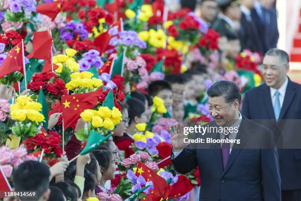 Xi Jinping, China's president, waves to children waving the flags of China and the Macao Special Administrative Region after arriving at Macau...