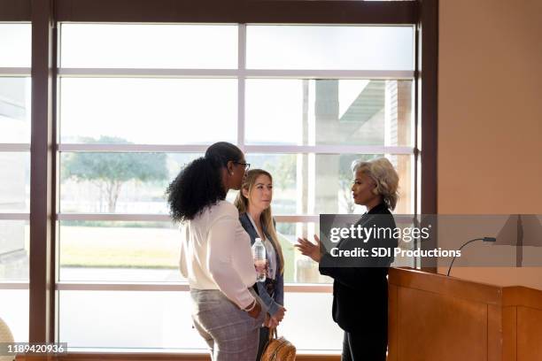business conference speaker talking with attendees - town hall meeting stock pictures, royalty-free photos & images
